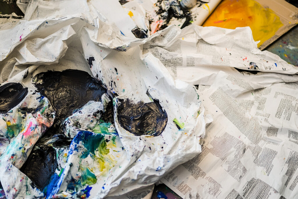 Protective clothing and workspace covered with newspapers to avoid acrylic paint spills on clothes.